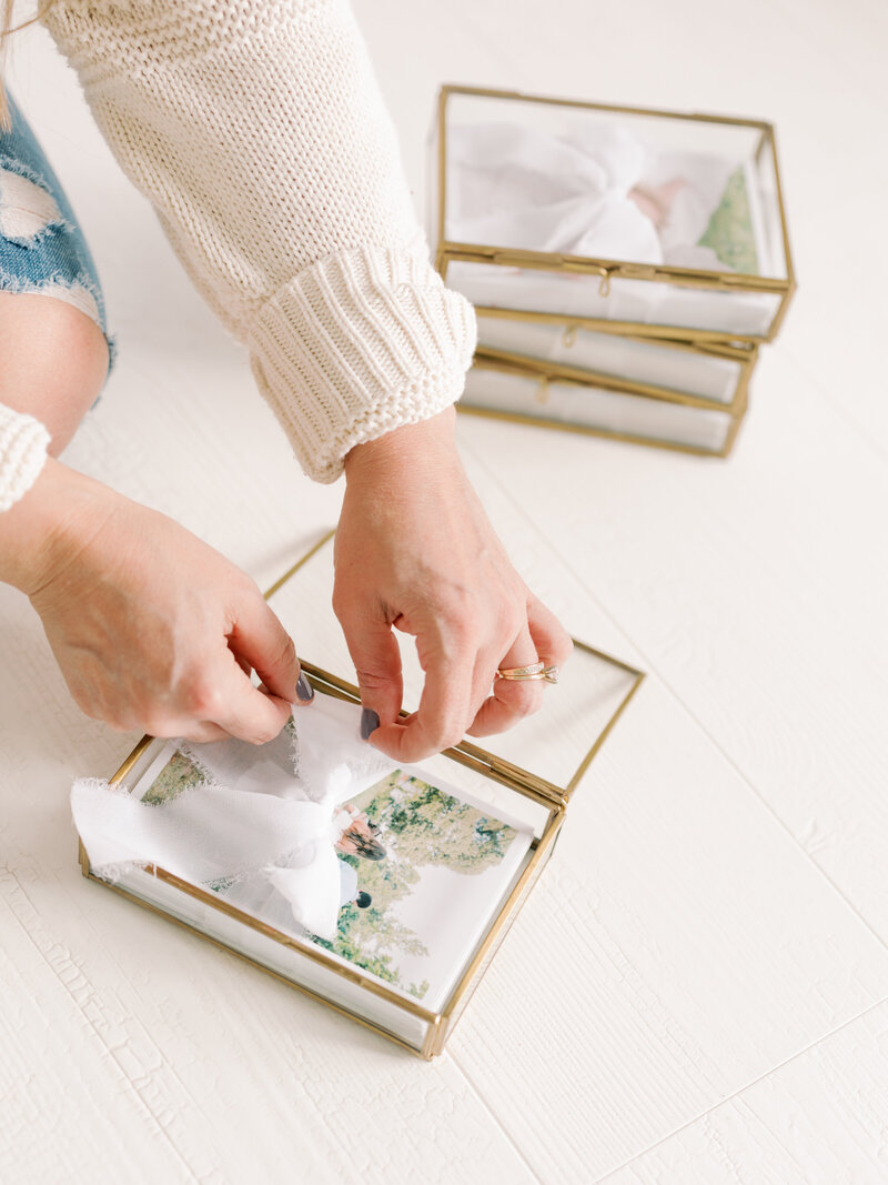 printed photos in glass presentation box sitting on top of heirloom album