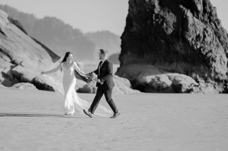 Bride and groom running down the beach on their wedding day in seattle