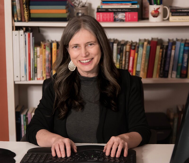 Rebecca in front of her bookshelf