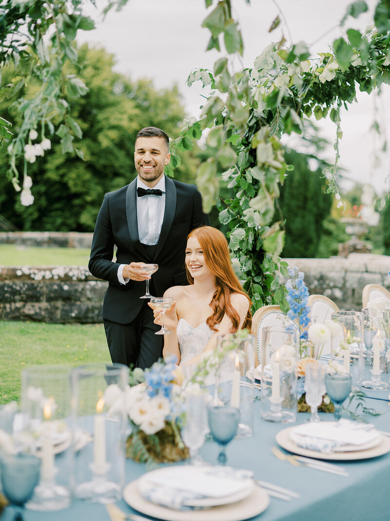 A-bride-and-groom-sitting-at-a-table-in-a-garden