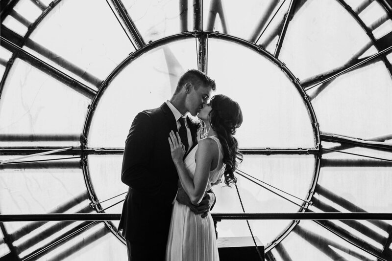 bride and groom kiss inside clocktower in denver black and white