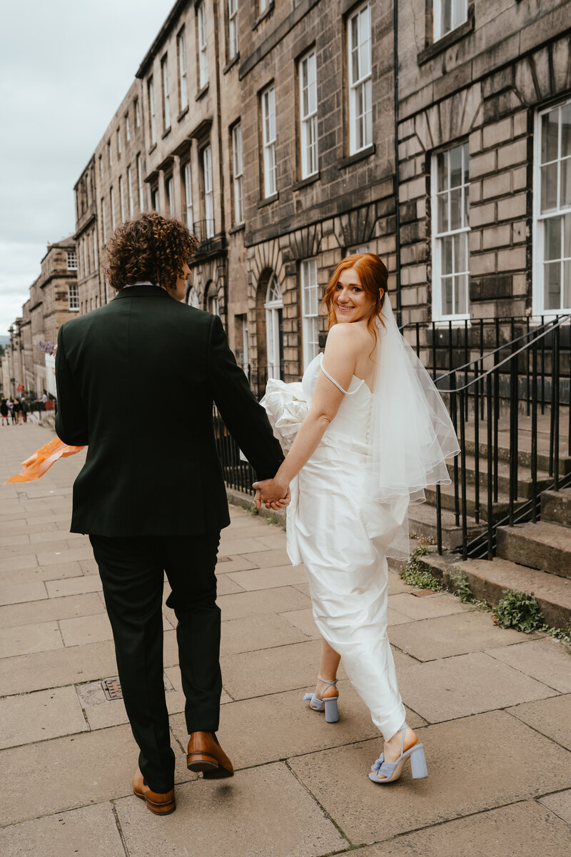 A newly married couple strut through Edinburgh after their ceremony at the Royal College of Physicians 