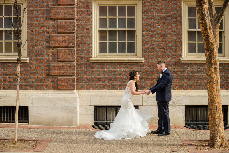 Bride and groom gasping in delight during their first look on the streets of historic Philadelphia, capturing their excitement.