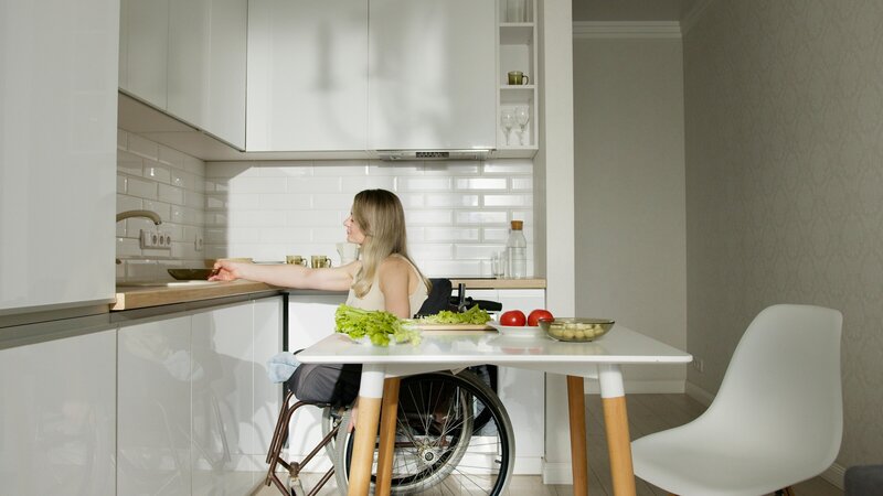 Woman in a wheelchair preparing food in the kitchen