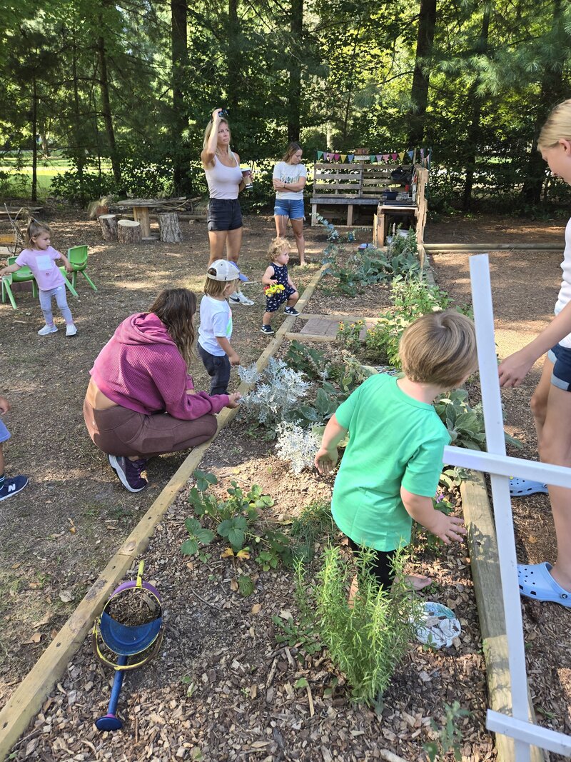 Children tending garden beds at ROOTS