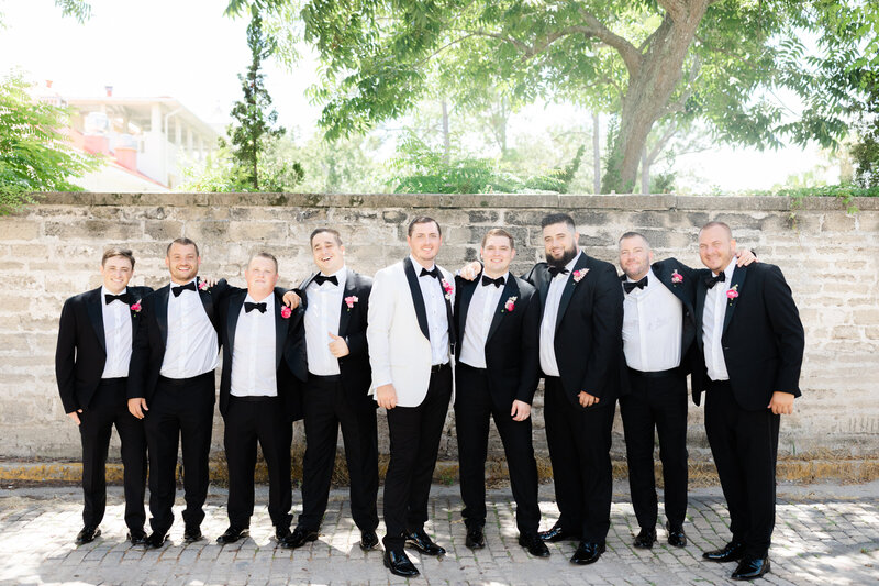 Groomsmen in black tux standing together during wedding party portraits in St. Augustine Florida