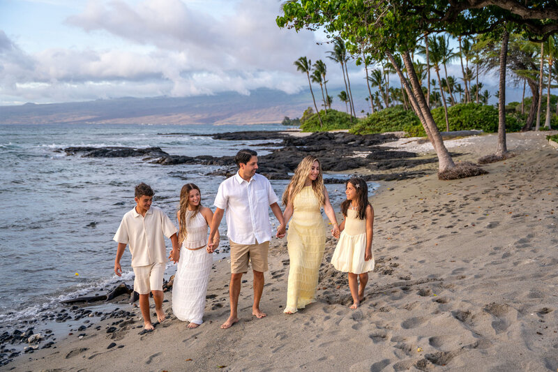 Family walking on beach taken by one of the best big island family photographers