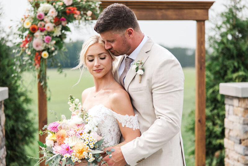 Groom holding bride, looking into each other eyes