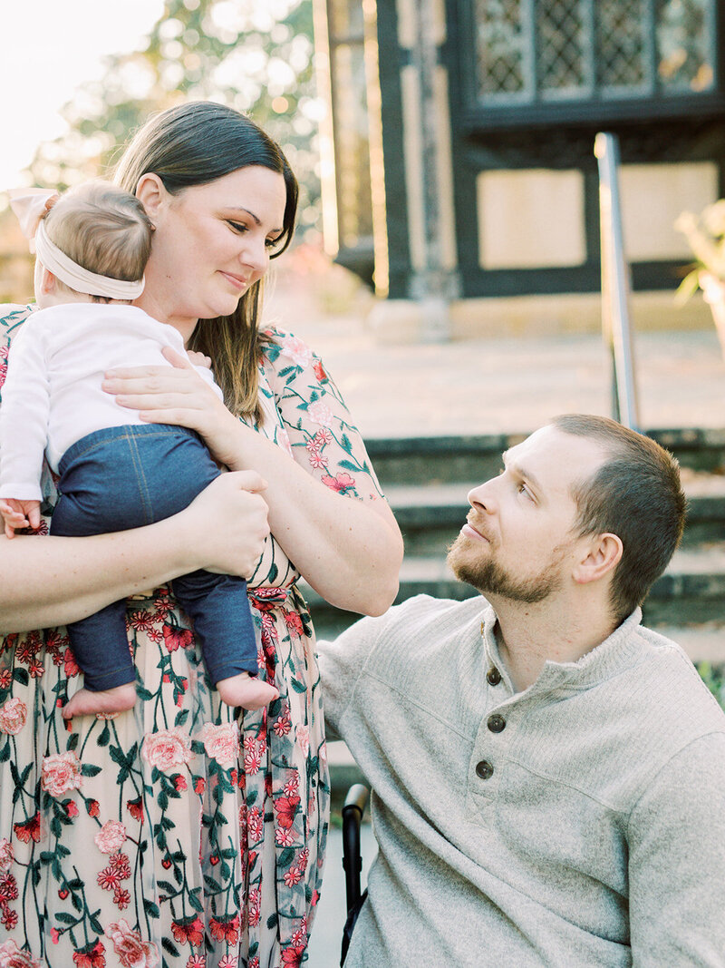A mother and father looking at each other while the mother is holding a baby at a Richmond family photography session by Katie Stansfield Photography.