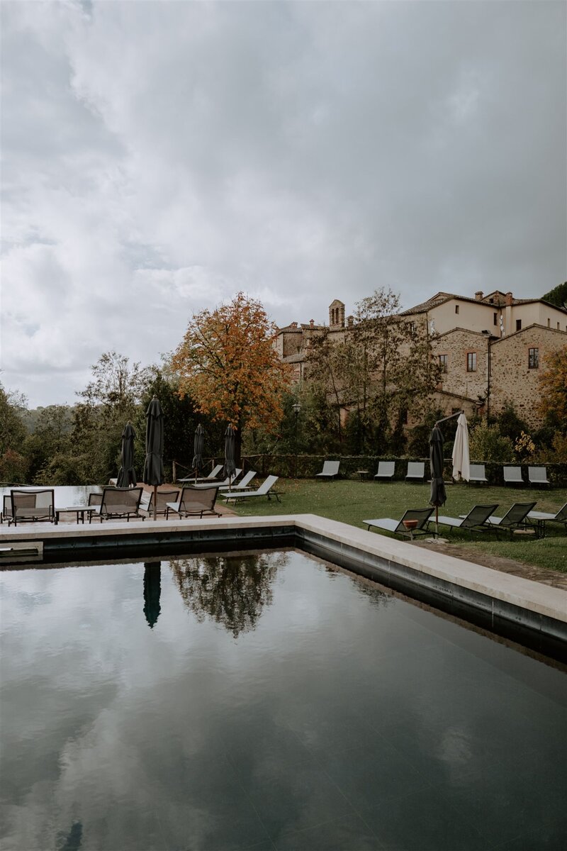 Charming stone villa with a serene pool and lounge chairs in a quiet European village, perfect for luxury escapes.