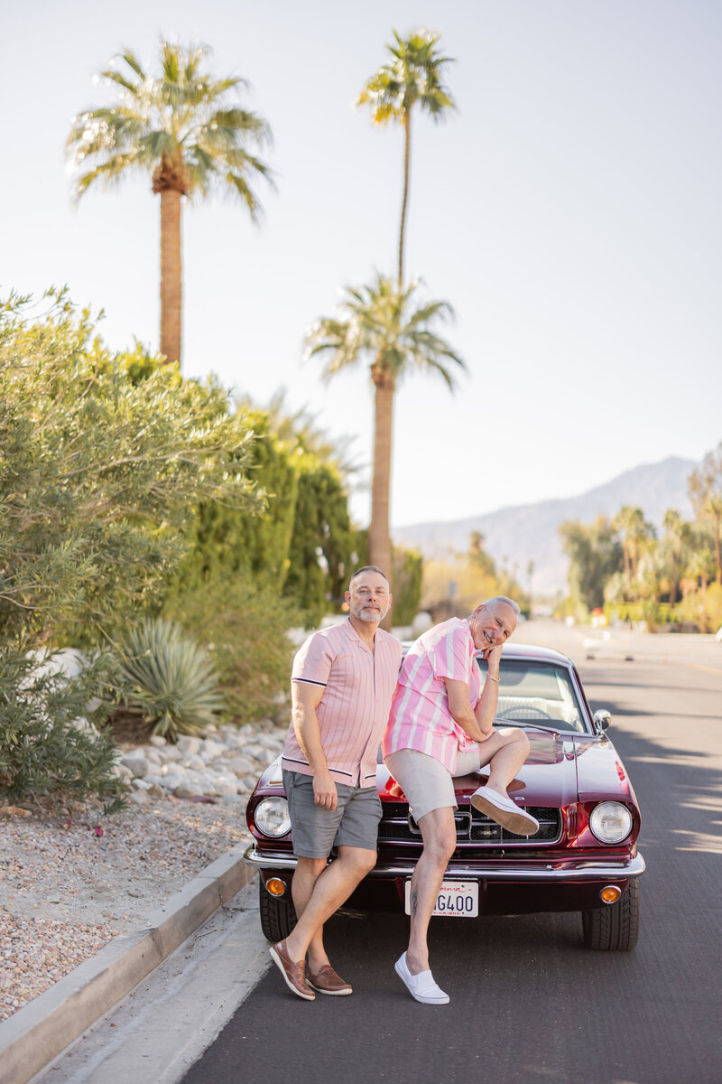 Couple sharing a joyful moment while seated in the back of a vintage mustang in Palm Springs