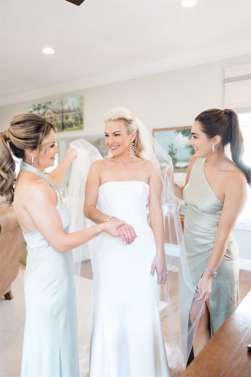 Bride getting dressed with her girls by Orlando wedding photographer