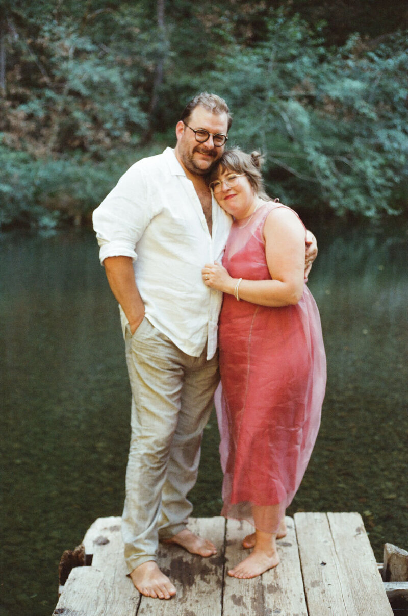 Relaxed Camp Noyo wedding portrait with barefoot couple on dock, bride in red dress, Northern California film photography.