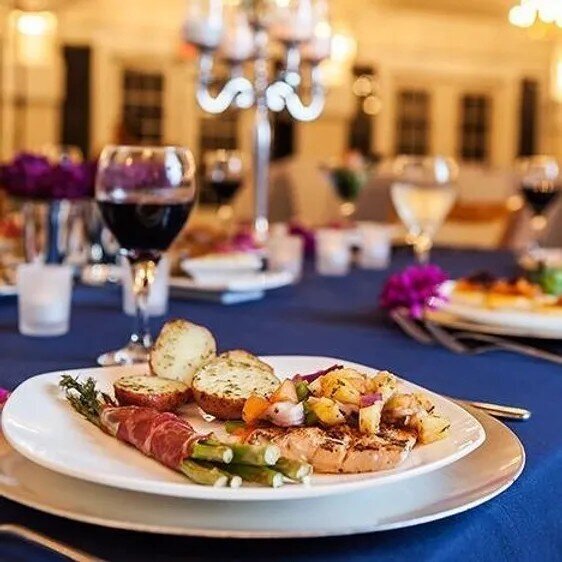 White plate with food and glass of wine