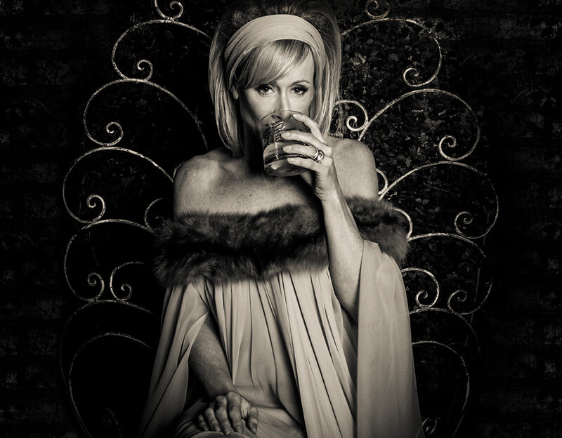 Personal Style Consultation Image Andra Liemandt sitting in fur trimmed gown sipping from glass sepia toned black and white