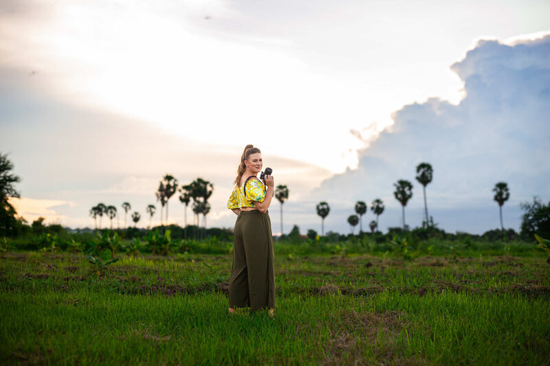 beautiful girl smiles holding camera at studio in Bali