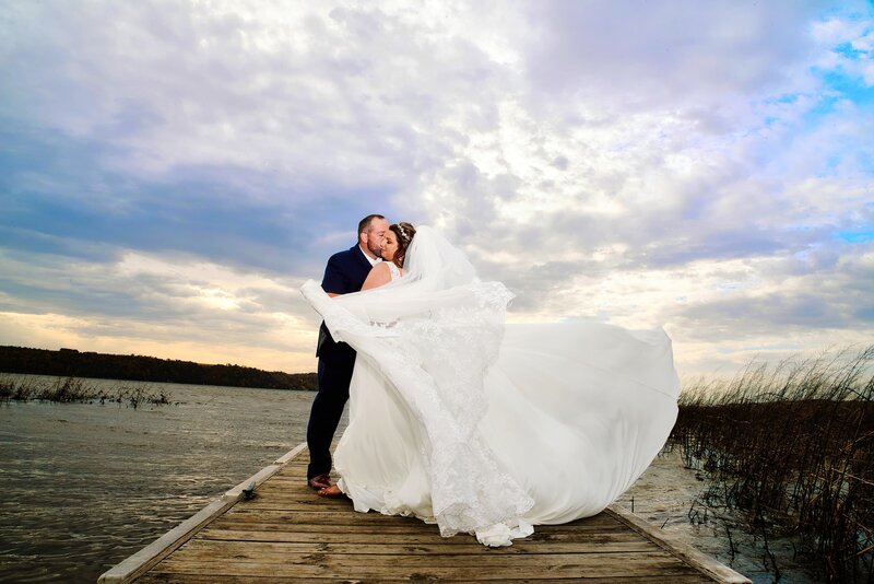 bride and groom on lake dock