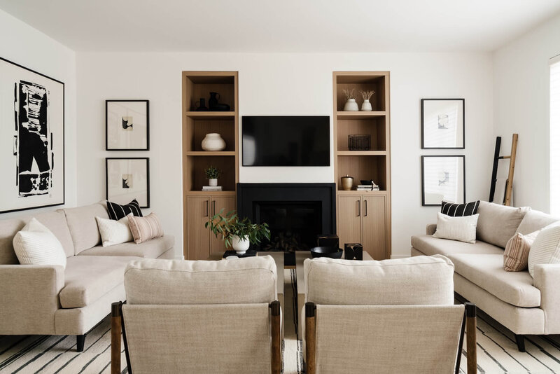Living room with black plaster fireplace, white oak built ins and abstract artwork. 
