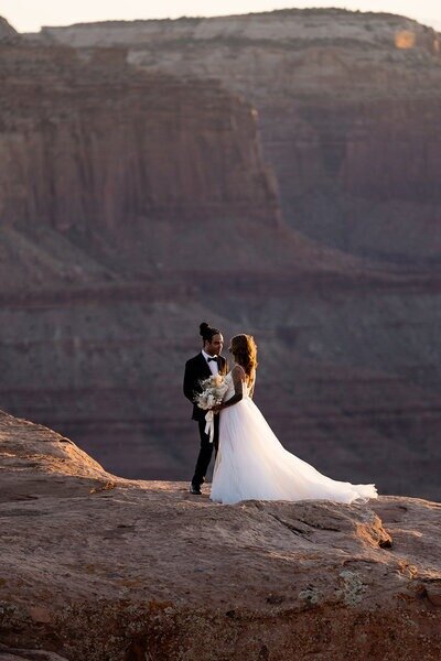 Couple enjoying the sunset just before twilight with mountains all around them in moab