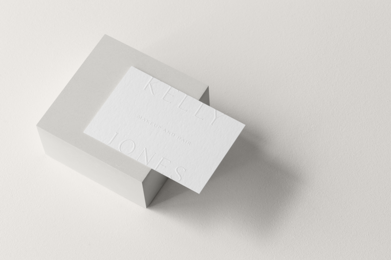 White business card with logo embossed on top of grey box.