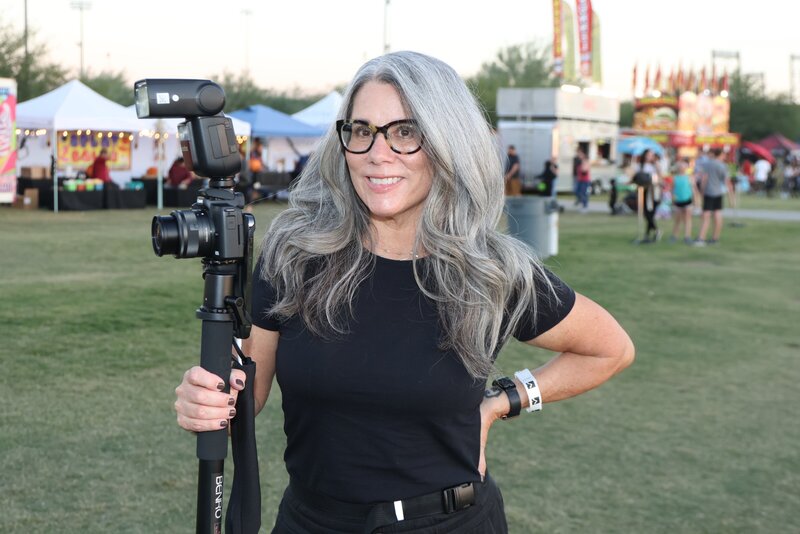 MISGIF event photographer holding a camera on-location at a Phoenix corporate event, delivering professional photography services for brand activations and festivals.