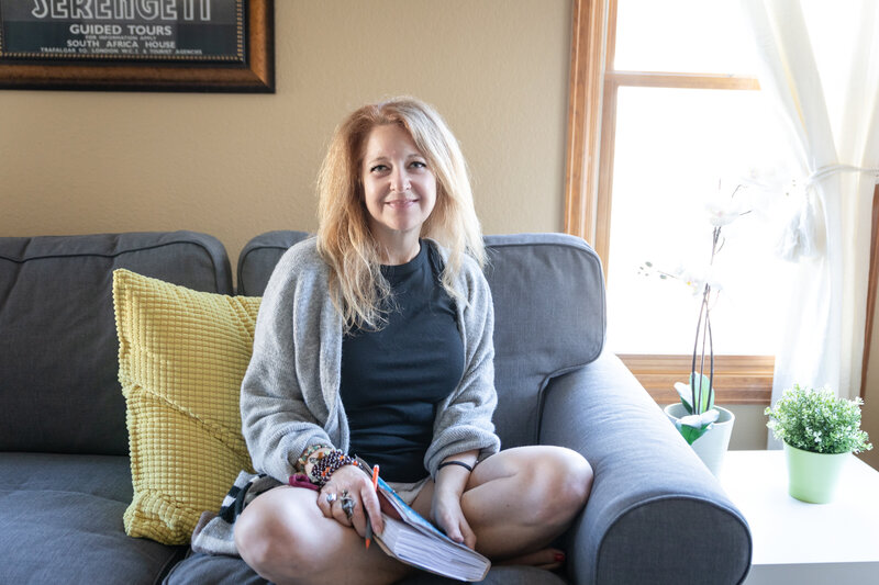 Cyndi Stewart sits behind her desk, smiling at the camera