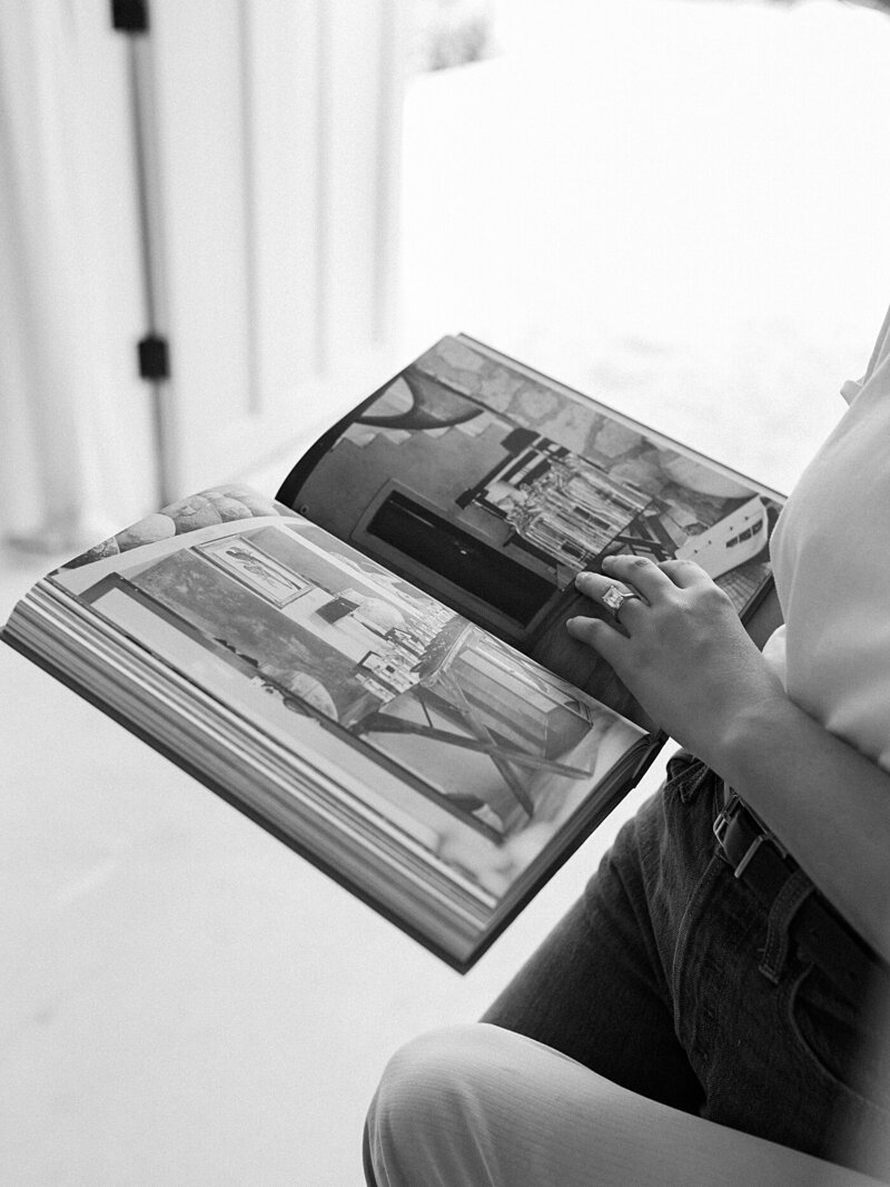 a fashion book open with a woman's hand on it