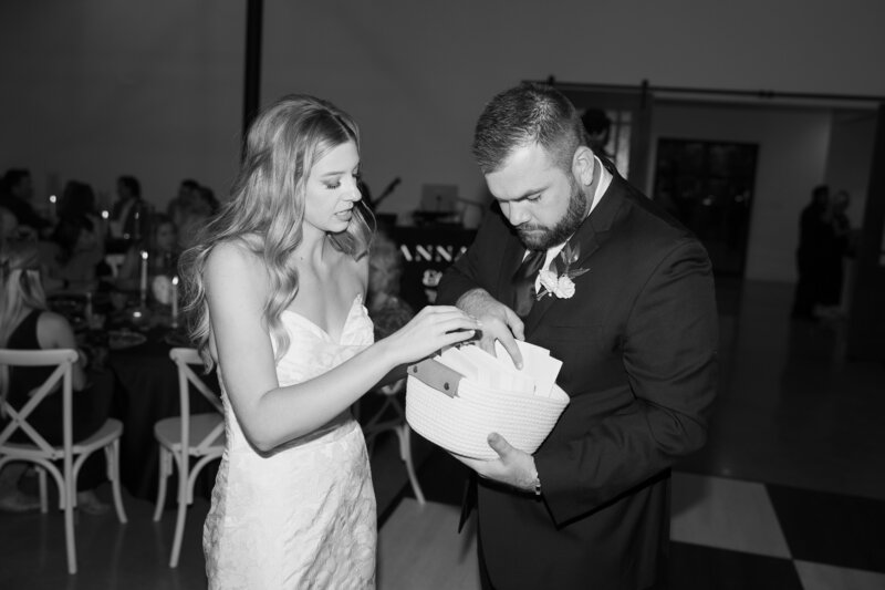 bride and groom passing out letters to guests