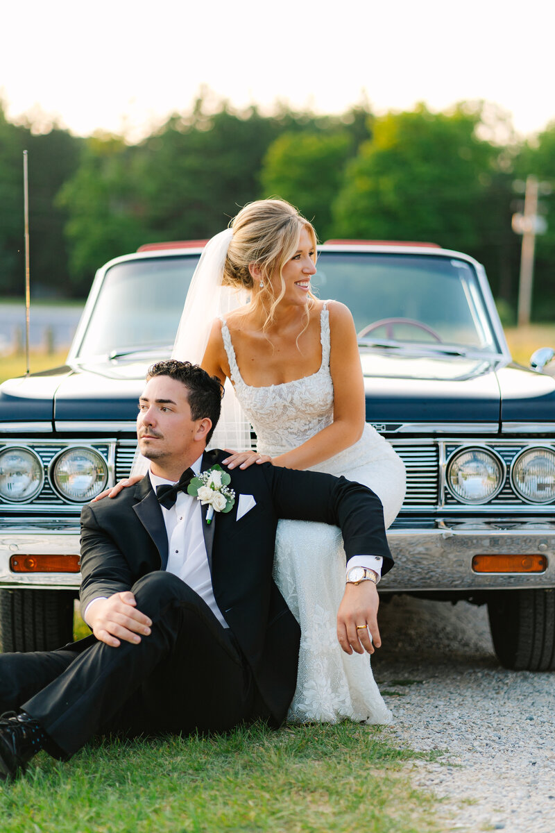 bride and groom in front of old time car