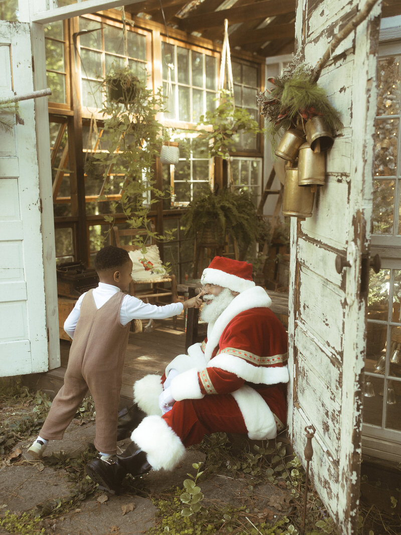 A little boy boops The Black Santa of Atlanta on the nose at Das Hinterhaus.