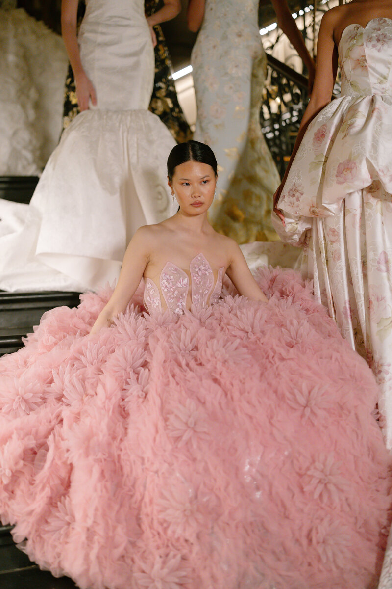 Model wearing pink tulle gown sat down