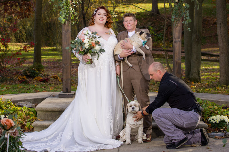 Photographer coordinating a family group photo featuring the bride and her dogs, capturing a loving and personal moment.