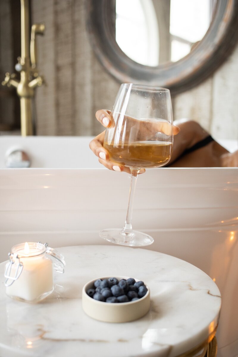 Woman sipping wine in bath