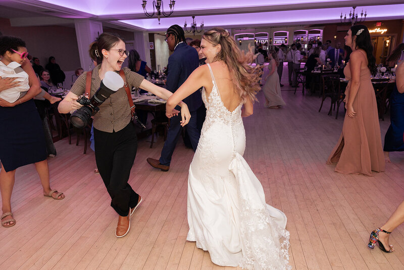 a wedding photographer dancing with the bride during the reception in a new jersey wedding venue
