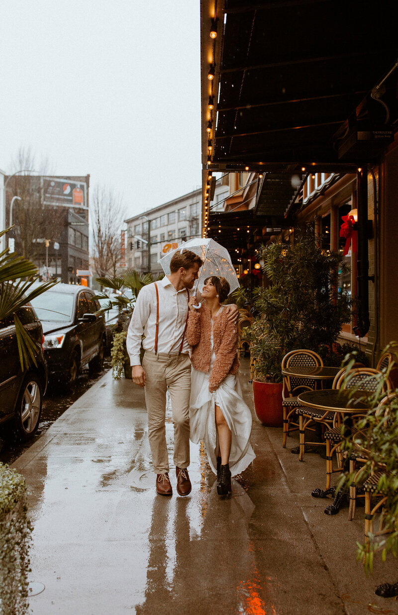 couple walking downtown in the rain