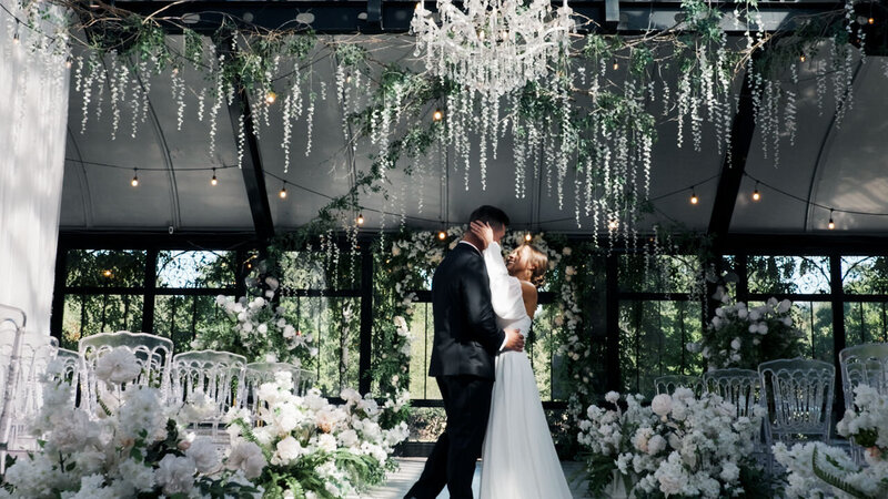A newlywed couple with their arms around each other dancing 