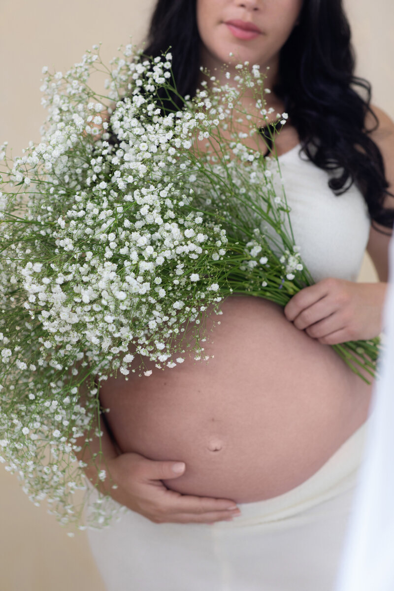 Expecting Mom posing with baby's breath in studio in LA