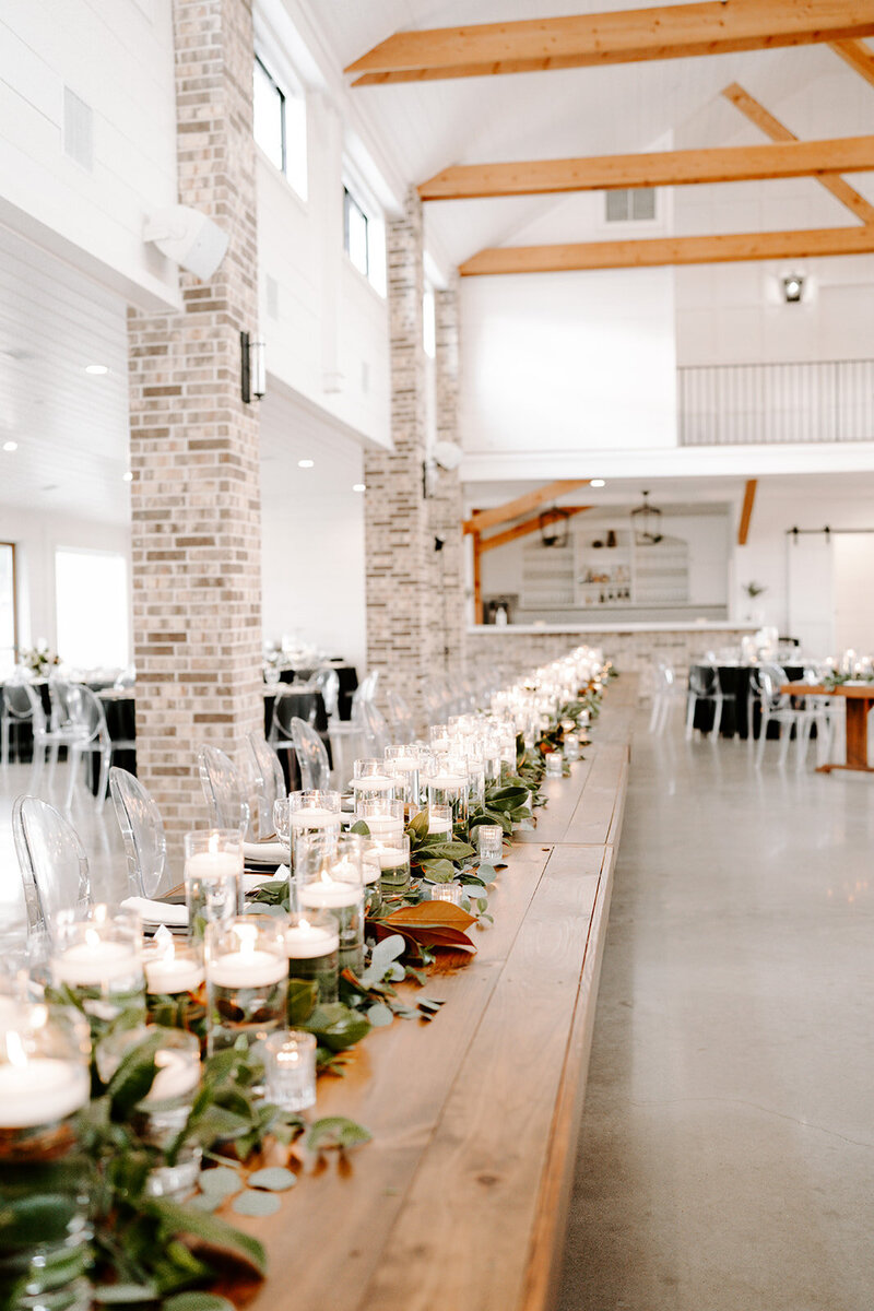 Swank Soiree Dallas Wedding Planner Haile and Christian - barn reception venue table settings with greenery and candles