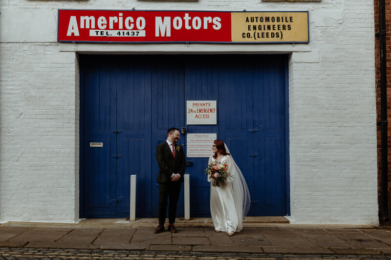 bride and groom standing together  in the tsreet in Leeds