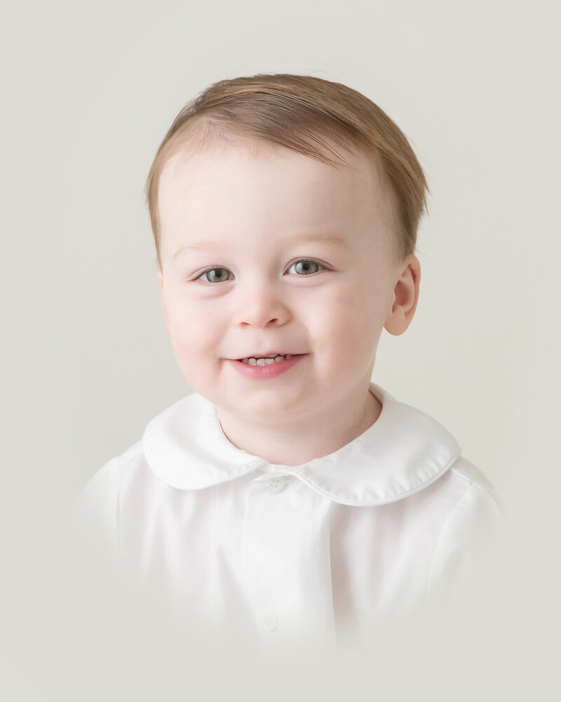 Little boy smiles sweetly as he poses for an Heirloom Portrait in Raleigh NC by Christy Johnson Photography