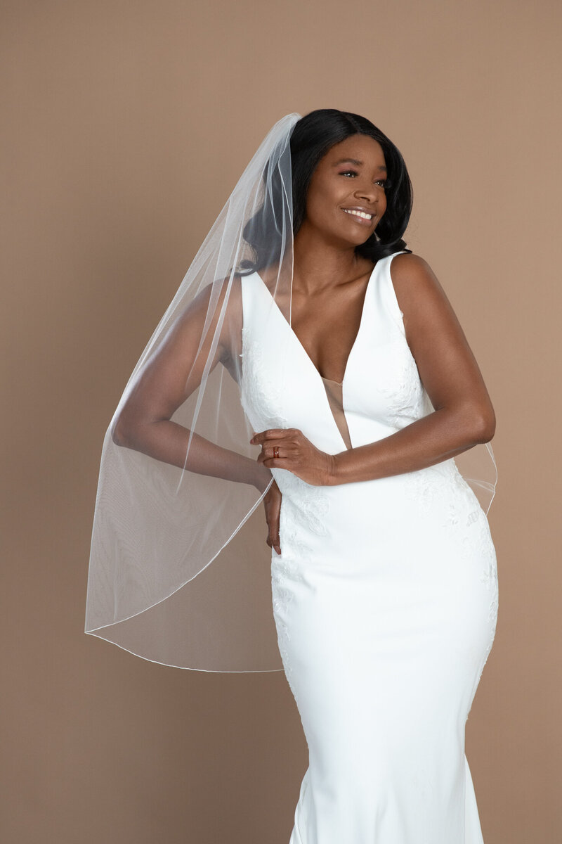 Bride wearing a fingertip length veil with small serged edge