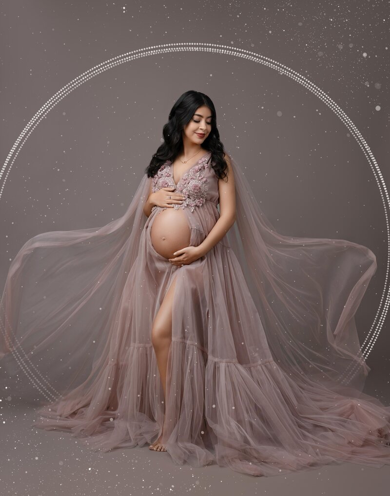 Pregnancy photo of Mom in mauve dress with fabric flowing. Photo was photographed in studio at Jenni Nikki's Atlanta photo studio.