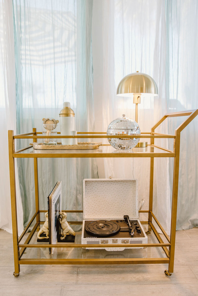 gold metal bar cart with record player