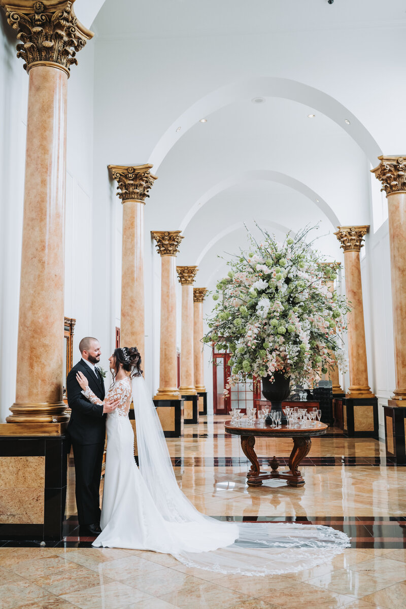 Bride and Groom embracing in a beautiful long hall