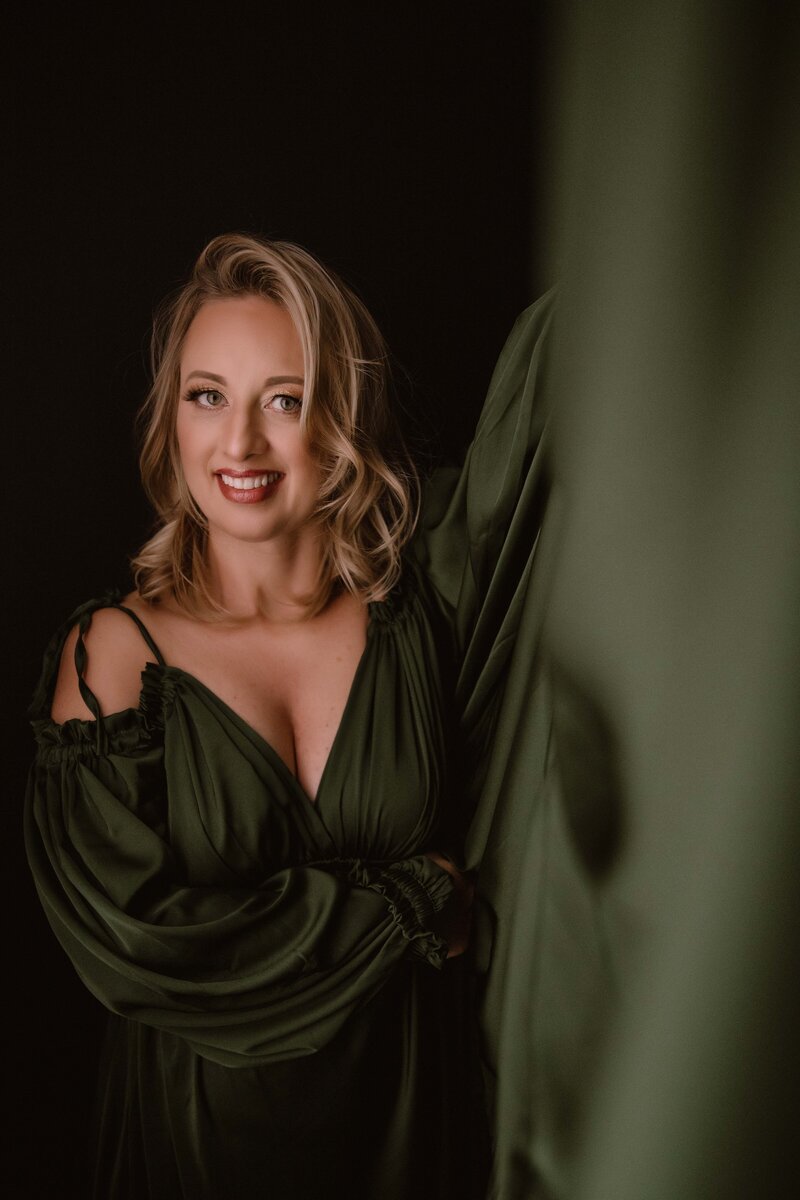 Smiling woman with shoulder length blonde hair wearing a green dress