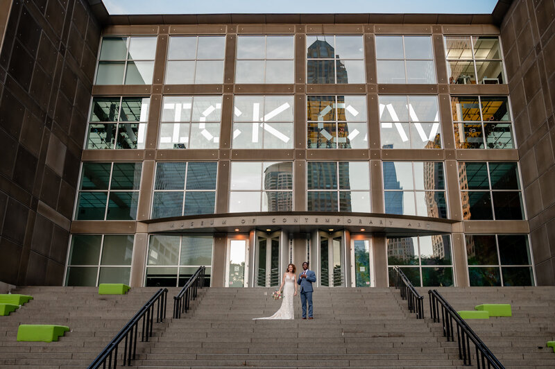 Bride and groom walk down stairs at Museum of Contemporary Art unique wedding venue in Chicago, IL