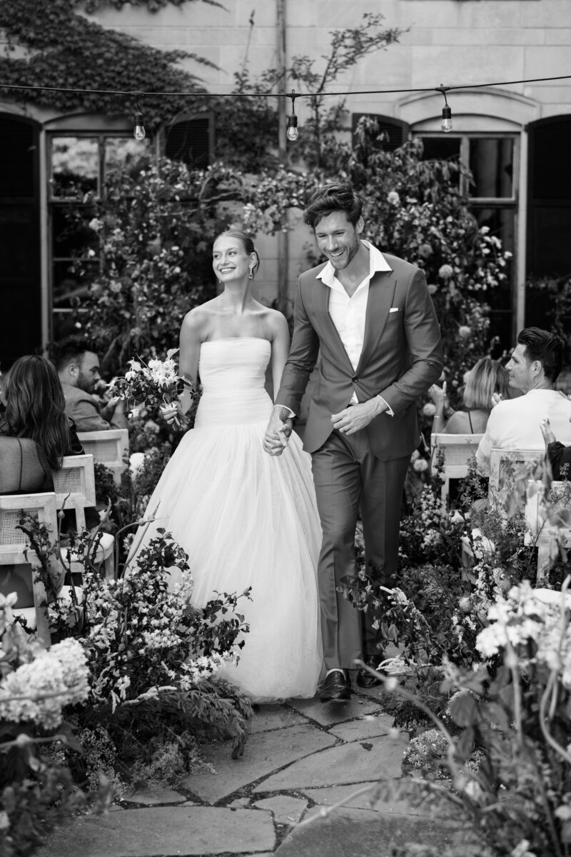 Stunning ceremony exit with bride wearing a Varca gown by Lexie Vaccaro Photography