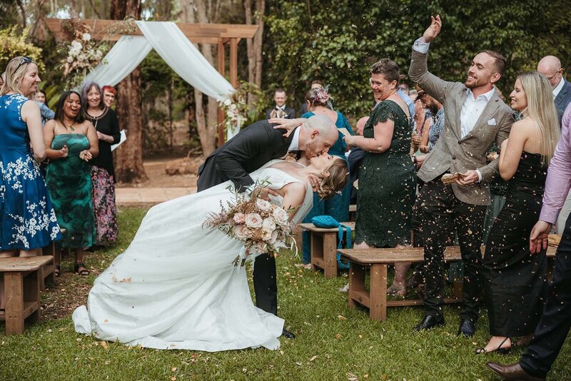 A bride petting her dog after putting on her dress