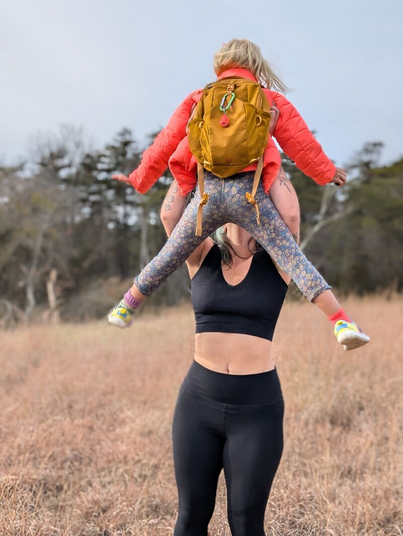 Julie Pokorny lifting her 6 year old above her head as they play outside in Baltimore , Maryland. Represents strength, play, and happiness. 