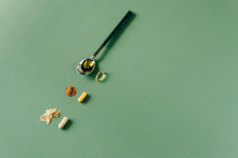 a spoon with serum and other vitamins and wellness items